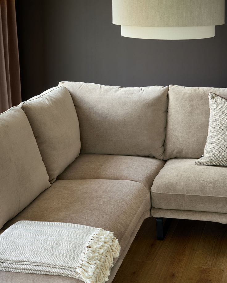 Colette left-hand corner chaise sofa in mink fabric, angled view showing cushioned seating and textured throw blanket.