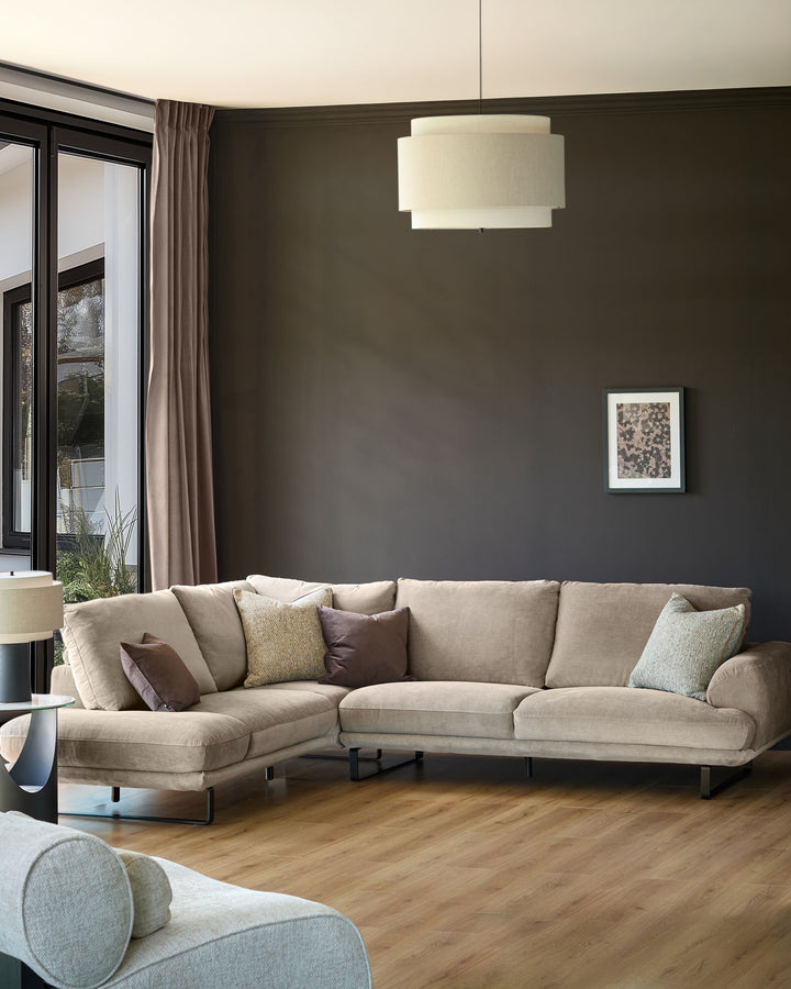 Mink fabric left-hand corner chaise sofa with curved arms and metal legs in a modern living room setting.