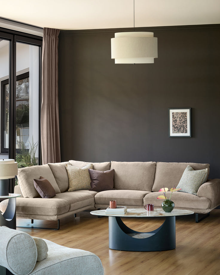 Mink fabric left-hand corner chaise sectional sofa with curved design and decorative pillows in modern living room setting.