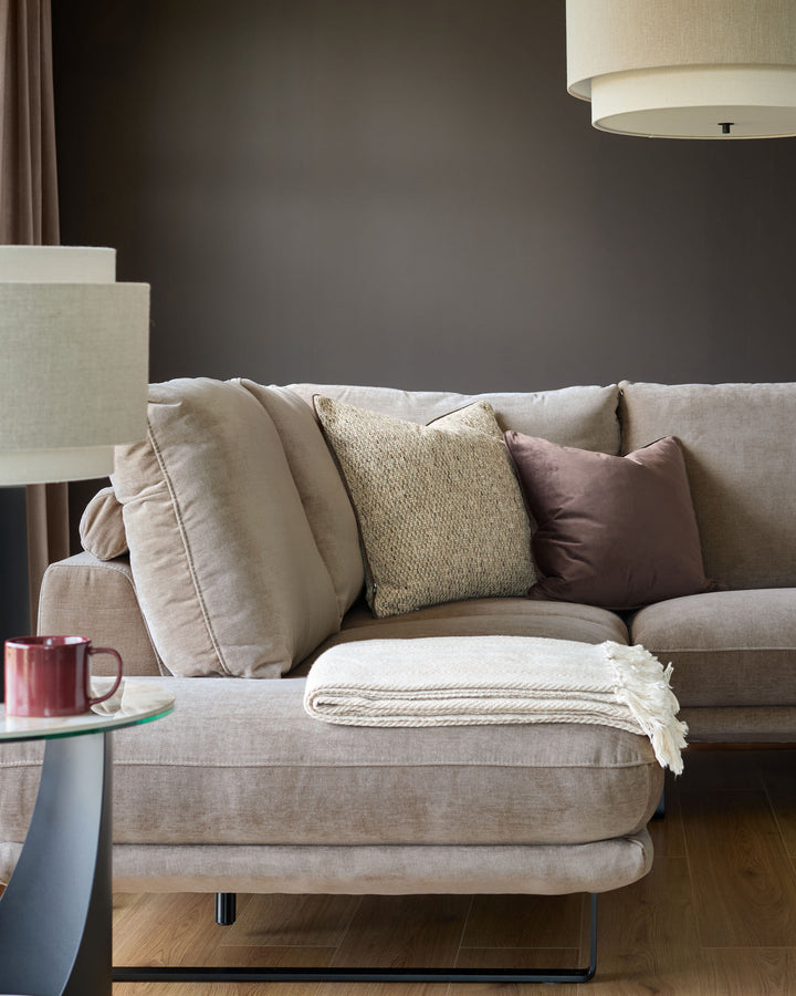 Colette left-hand corner chaise sofa in mink fabric, styled with coordinating pillows and a cream throw blanket.