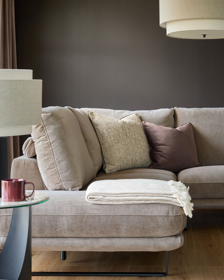 Colette left-hand corner chaise sofa in mink fabric, styled with coordinating pillows and a cream throw blanket.