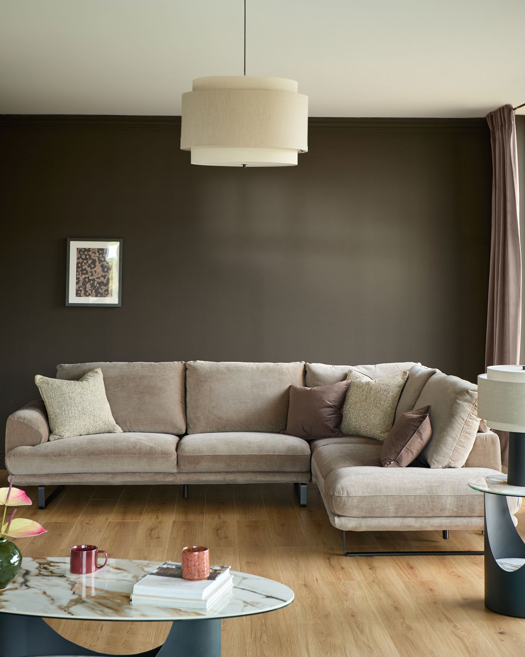 Mink fabric right-hand corner chaise sofa in modern living room setting with accent pillows and metal legs.