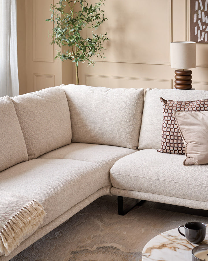 Colette left-hand corner chaise sofa in natural fabric, styled with decorative pillows and throw in a neutral living room setting.