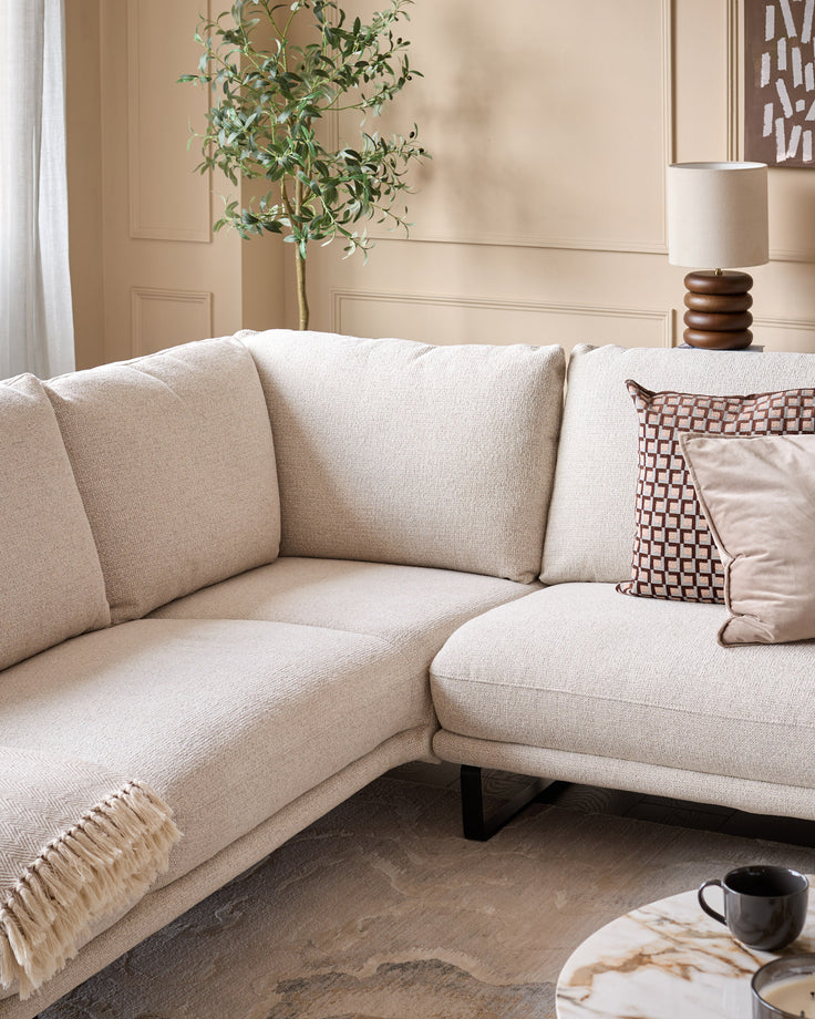 Colette left-hand corner chaise sofa in natural fabric, styled with decorative pillows and throw in a neutral living room setting.
