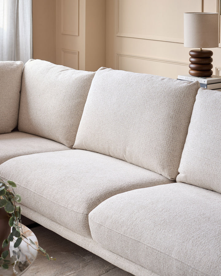 Colette left-hand corner chaise sofa in natural fabric, shown from a side angle displaying plush cushions and modern silhouette.