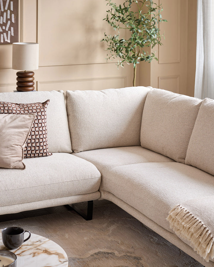 Colette right-hand corner chaise sofa in natural fabric, displayed in a styled living room setting with cushions and throw.
