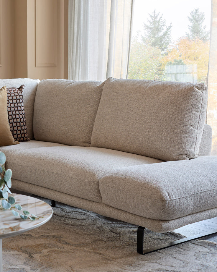 Colette right-hand corner chaise sofa in natural fabric, angled view showing cushioned seat and back with decorative pillow.