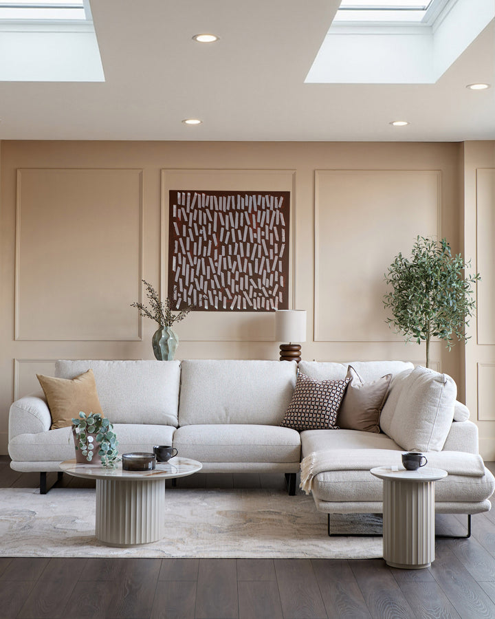 Colette right-hand corner chaise sofa in natural fabric, displayed in a modern living room setting with coordinating pillows.