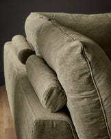Colette left-hand corner chaise sofa in olive green fabric, shown at an angle highlighting the curved armrest and cylindrical bolster cushion.
