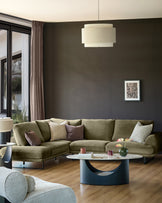 Olive green left-hand corner chaise sofa in a modern living room setting with neutral décor.