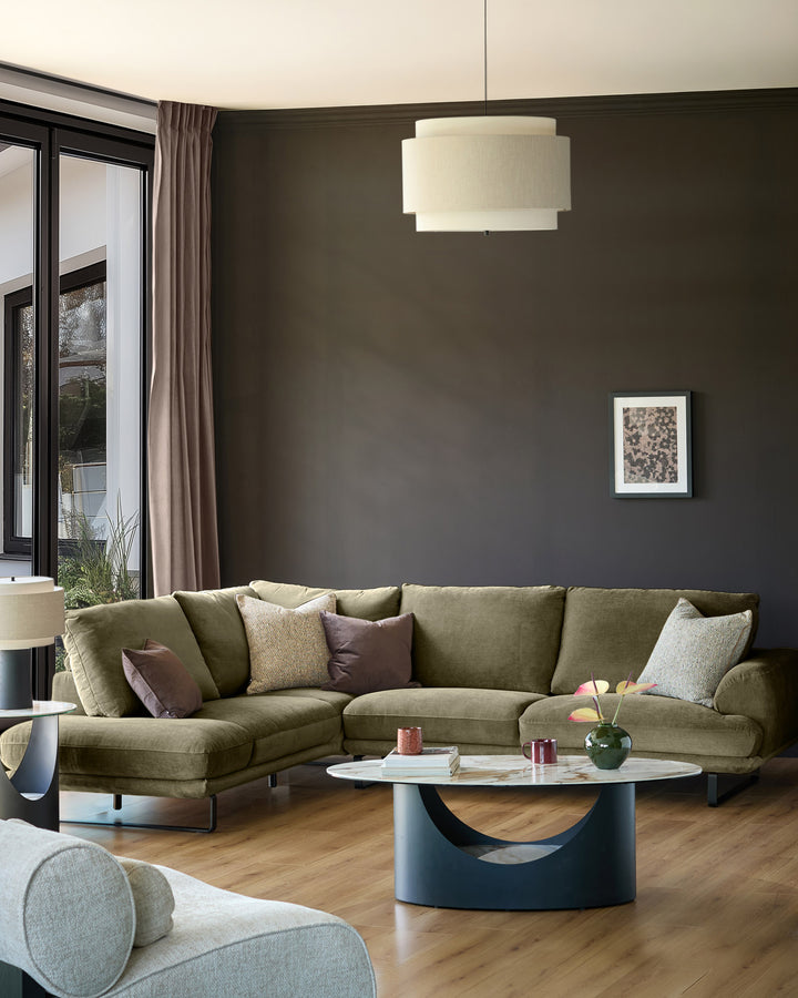 Olive green left-hand corner chaise sofa in a modern living room setting with neutral décor.