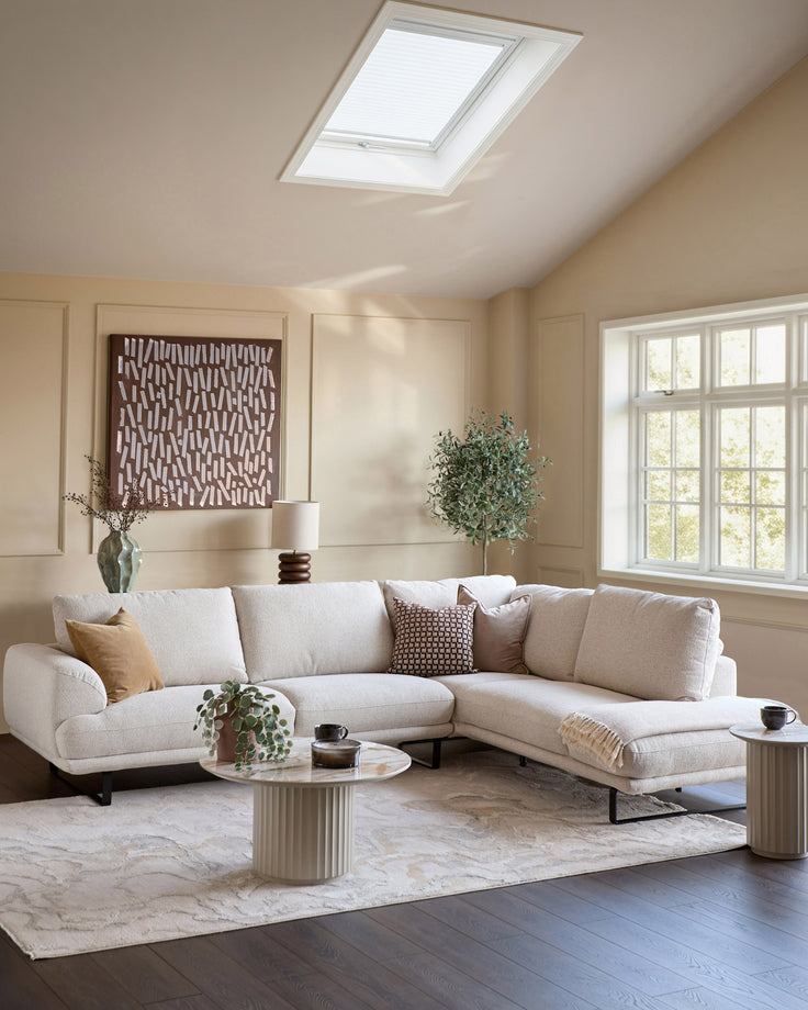Colette right-hand corner chaise sofa in natural fabric, displayed in a bright living room with skylight and large windows.