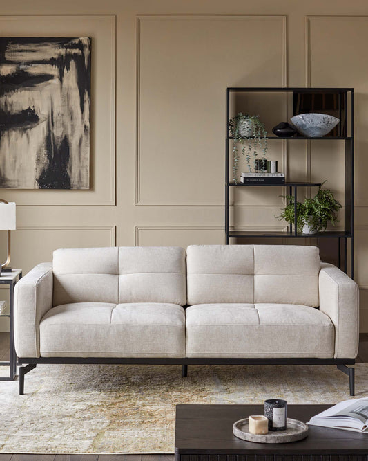 A modern living room featuring a fabric sofa, black shelving unit and dark wood coffee table, showcasing contemporary style.