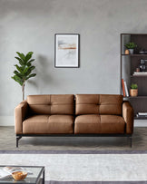 A stylish brown leather sofa takes centre stage in this modern living space, accompanied by a dark wood shelving unit and a lush plant.