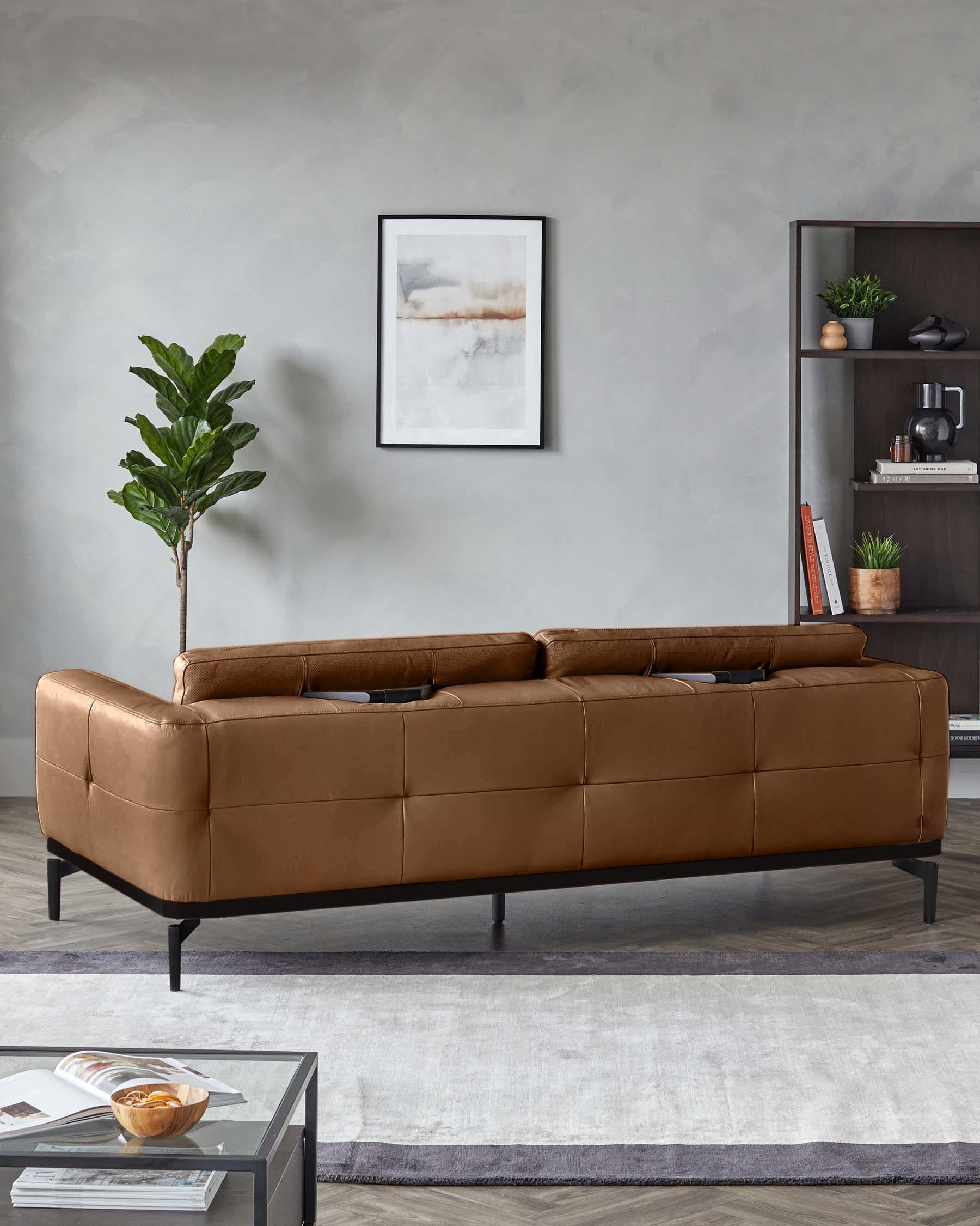 A tan leather sofa with a modern black frame, showcased in a styled living room setting.