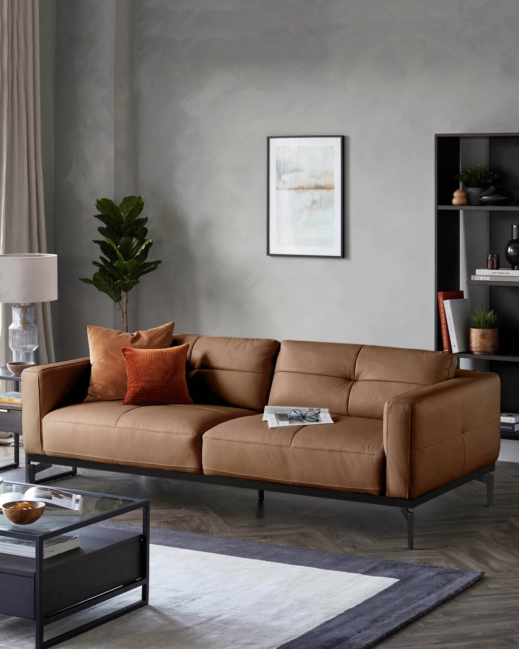 Stylish living room featuring a tan leather sofa with black frame, complemented by a glass coffee table and modern decor.