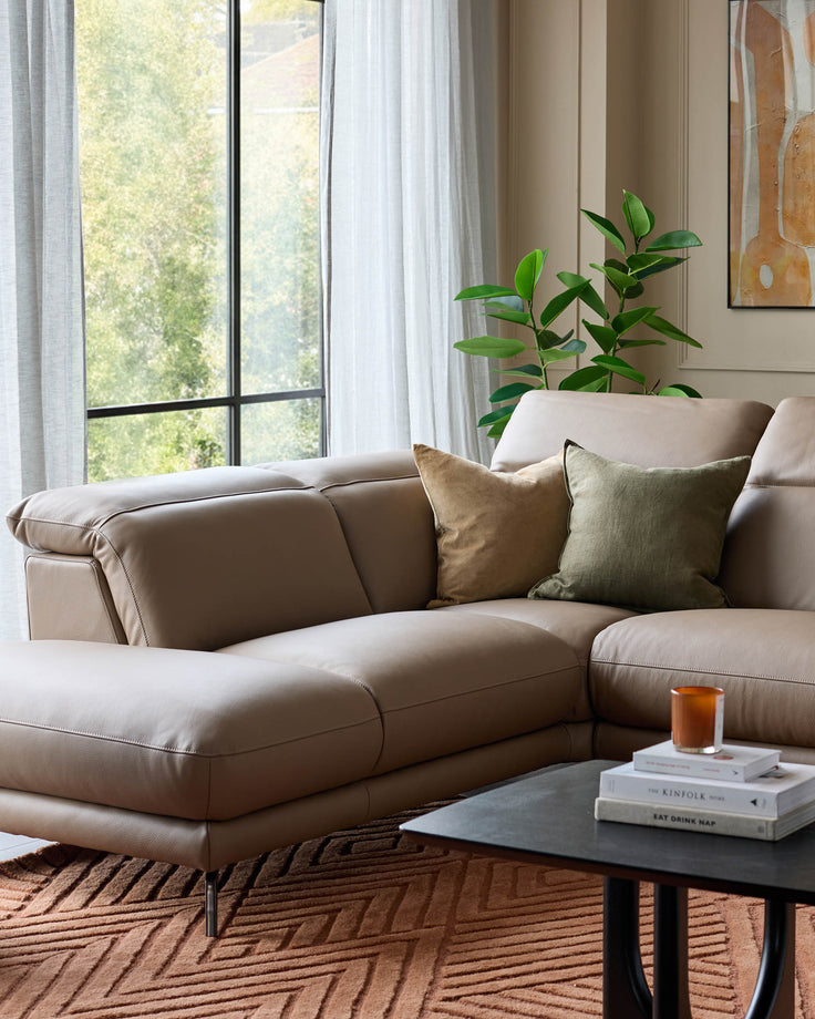 Connor left-hand corner chaise sofa in natural leather, displayed in a bright living room setting with cushions and plants.