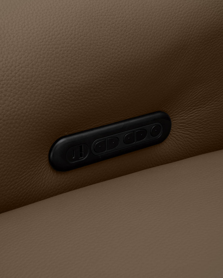 Black leather handle detail on a natural tan leather sofa arm, showing stitched design against textured upholstery.