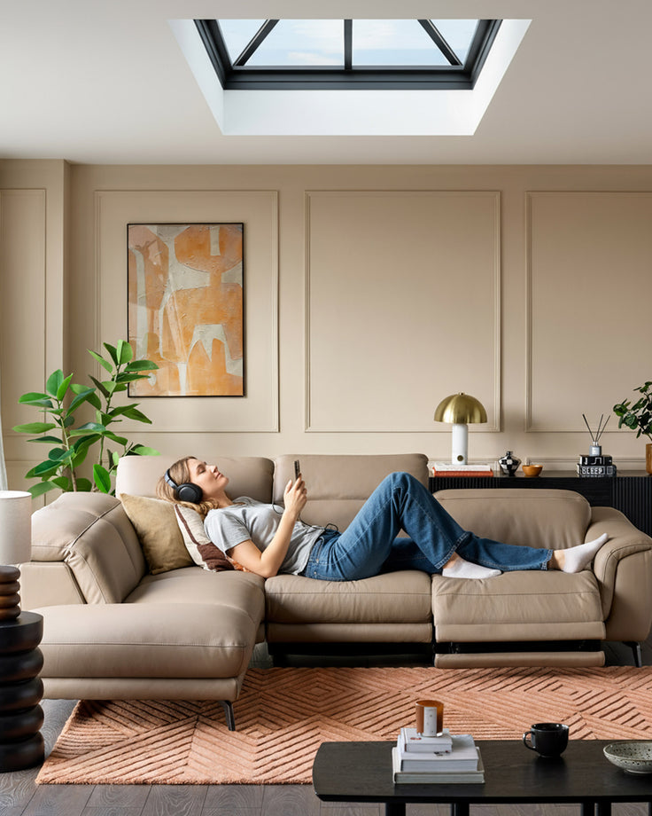 Connor left-hand corner chaise sofa in natural leather, styled in a modern living room with skylight and neutral décor.
