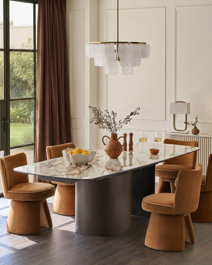 Cortona dining table in natural ceramic with marble top, shown with caramel leather chairs in modern dining room setting.
