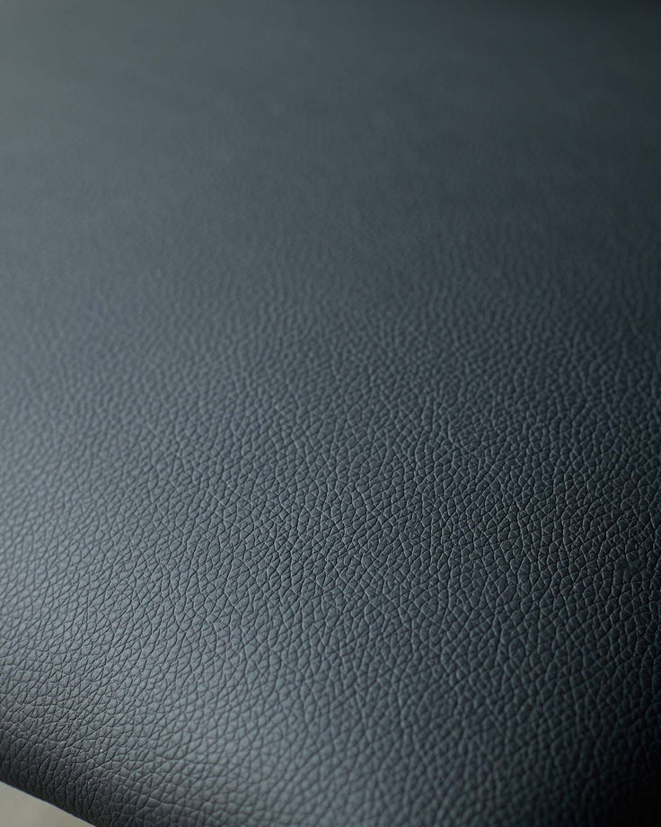 Close-up of textured black leather furniture, showcasing its fine grain and matte finish. Ideal for a sophisticated interior.