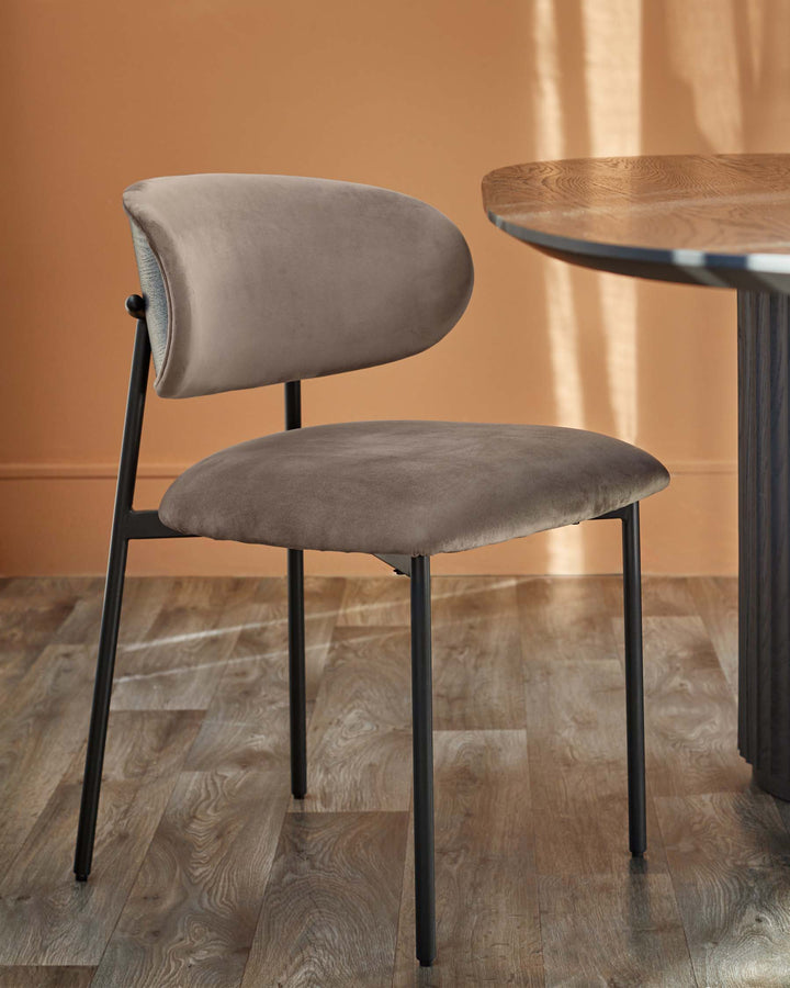 Stylish chair with a taupe velvet seat and back, paired with a round wooden table. Modern furniture design.