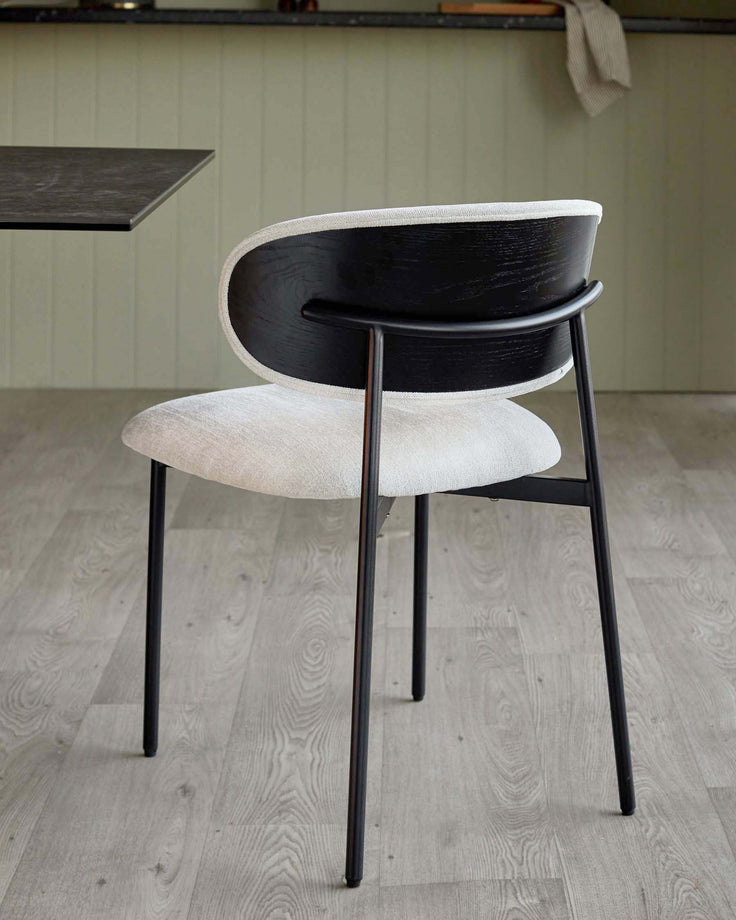 Elegant black and cream upholstered dining chair with sleek metal frame, adding style to any modern dining area.