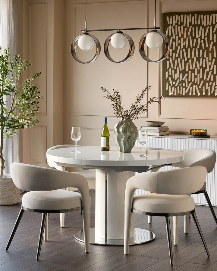 Curva gloss white round extending dining table styled in a modern dining room with cream chairs and pendant lighting.