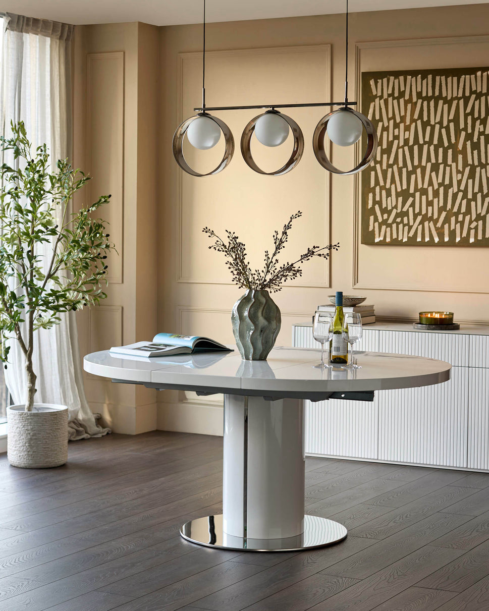 Curva white gloss round extending dining table with chrome base, displayed in a modern dining room setting.