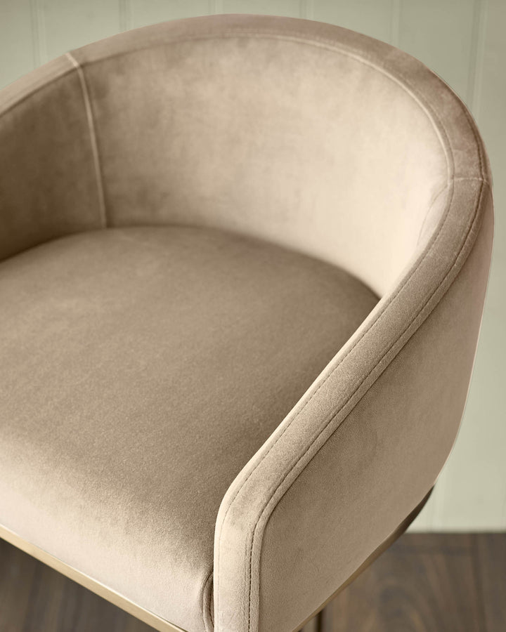 Champagne velvet barstool with curved back and brass base, shown from side angle detail view.