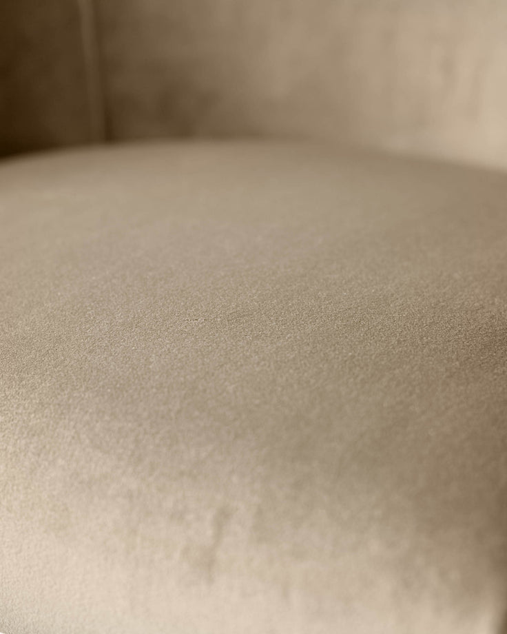 Dakota velvet barstool in champagne, close-up of upholstered seat texture and brass details.