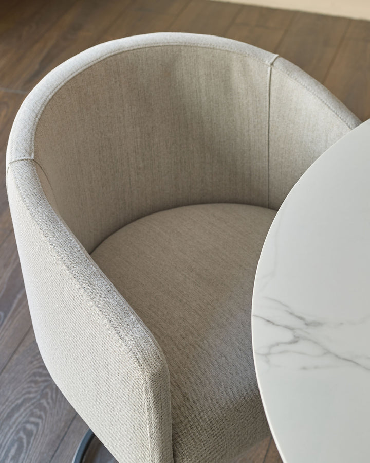 Dakota dining chair in natural fabric, overhead view showing curved backrest and seat.