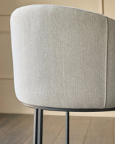 Dakota dining chair in natural fabric, shown from rear angle displaying curved backrest and metal legs.