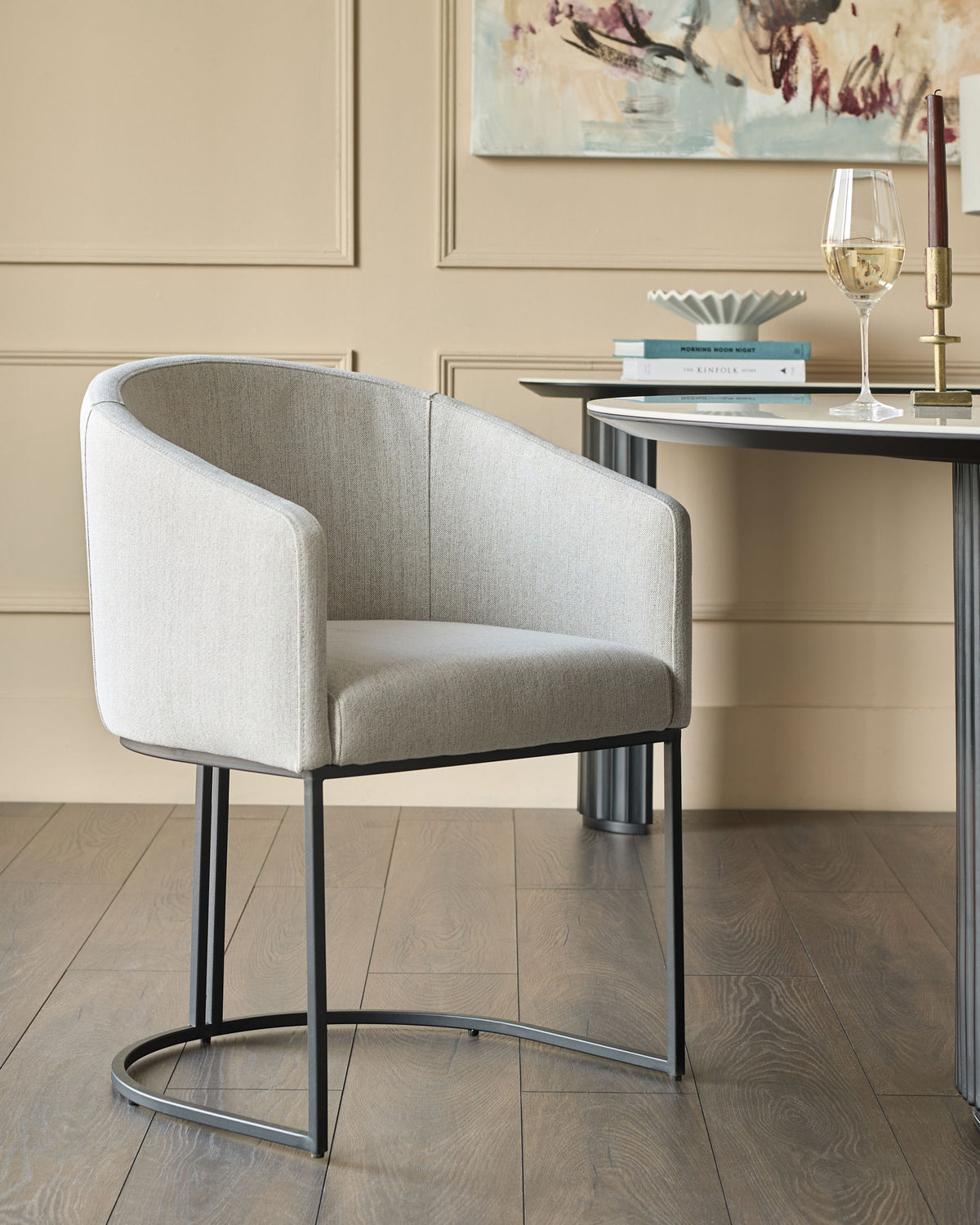Dakota dining chair in natural fabric with black metal frame, shown in a styled room setting.