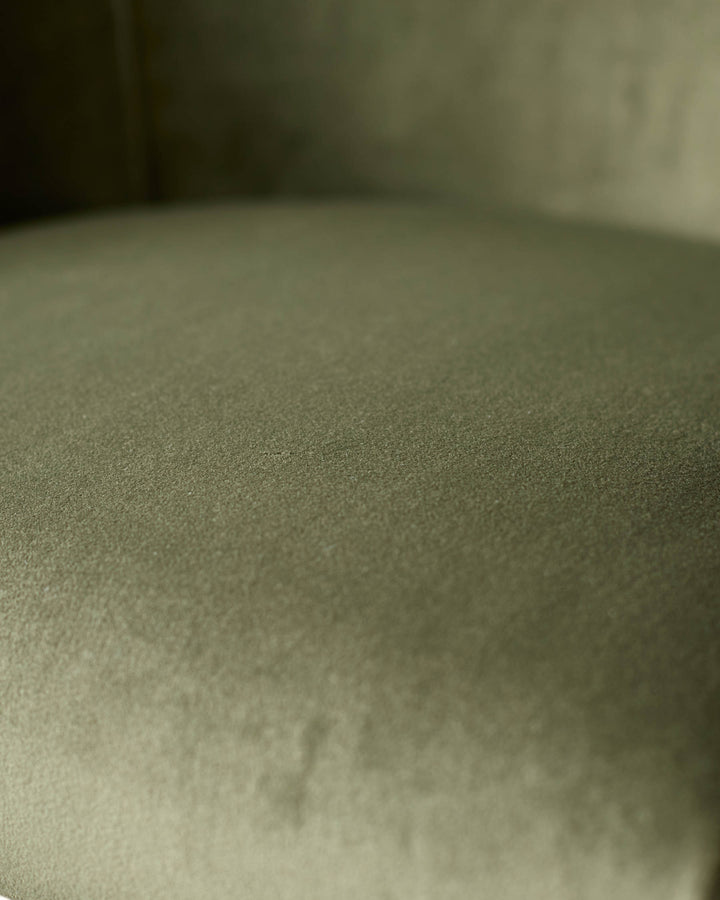 Close-up of olive green velvet upholstery texture on Dakota bar stool