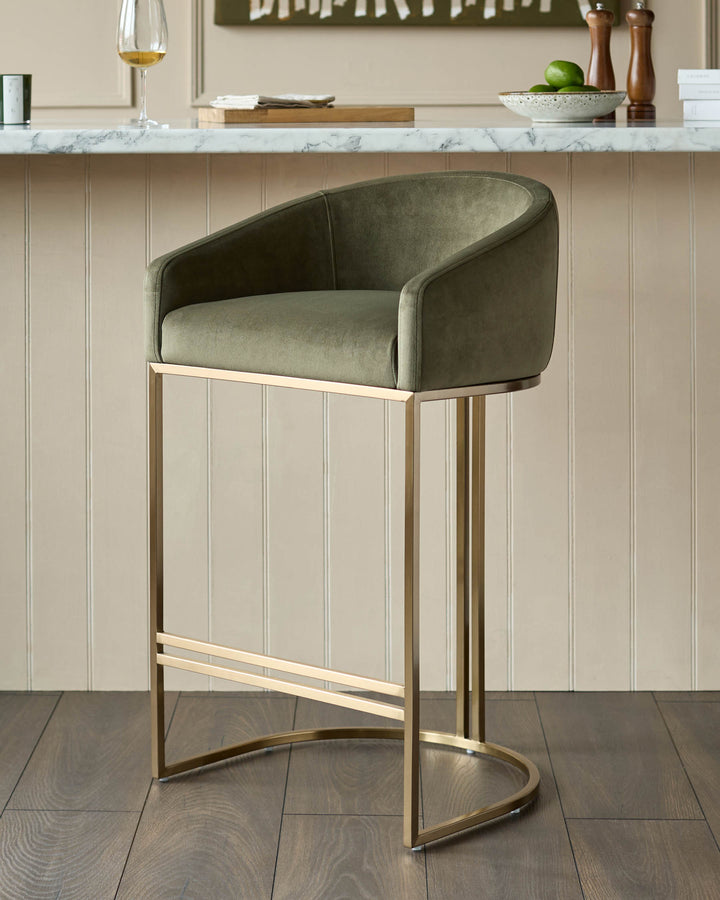 Dakota bar stool in olive green velvet with brushed gold metal frame, shown in kitchen setting.