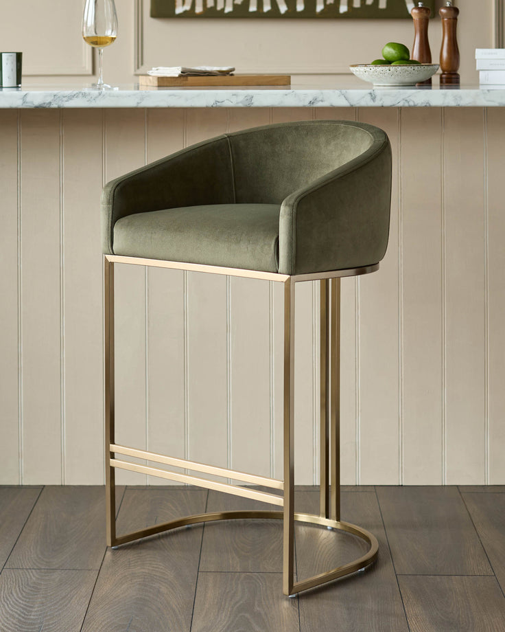 Dakota bar stool in olive green velvet with brushed gold metal frame, shown in kitchen setting.