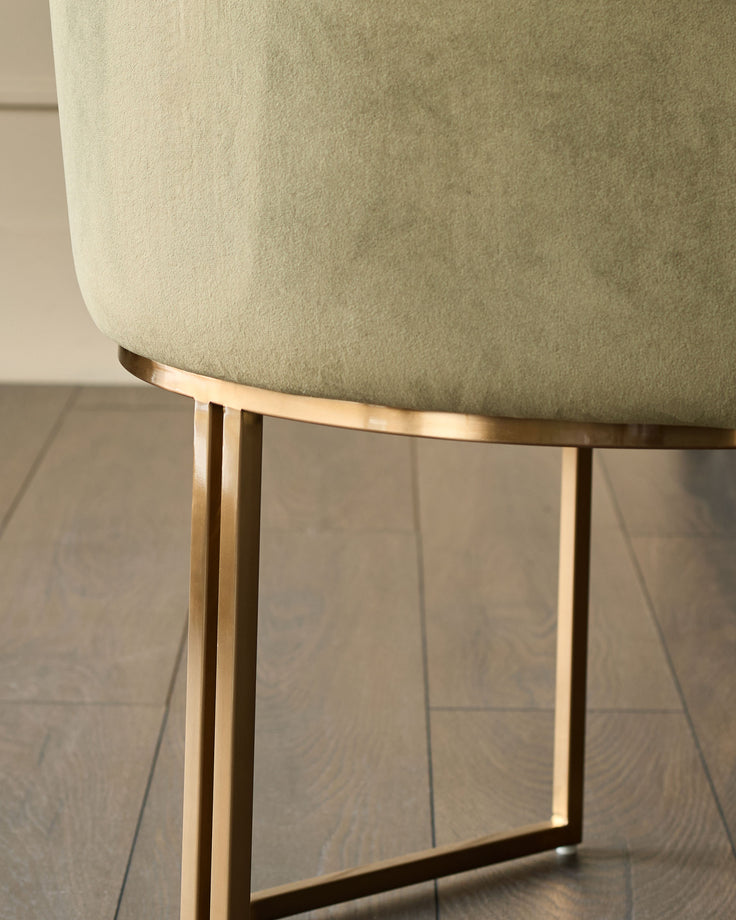 Dakota dining chair in olive green velvet with brushed gold metal base, side view detail.