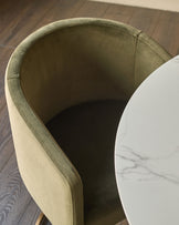 Dakota dining chair in olive green velvet, shown from above at an angle with white marble side table nearby.