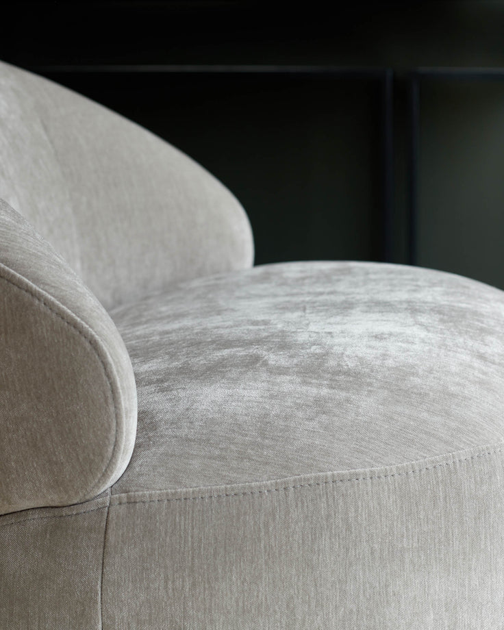 Close-up of a stylish, neutral-toned armchair with a soft, textured fabric. Perfect for adding comfort to any living space.