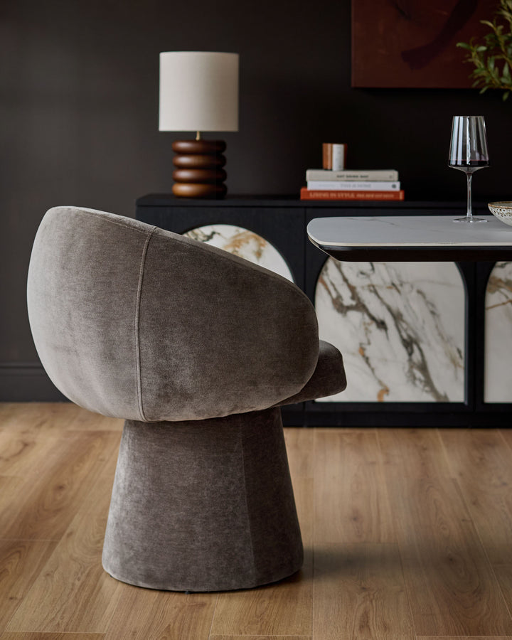 Darcy swivel dining chair in mocha fabric, shown from rear angle on wooden floor in modern dining setting.