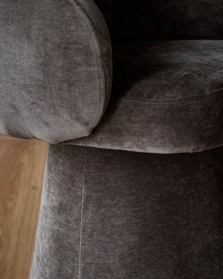 Darcy swivel dining chair in mocha fabric, close-up side view showing cushioned seat and backrest detail.