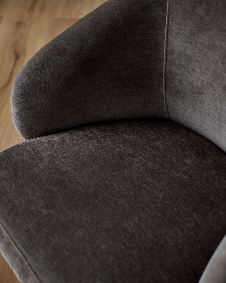 Darcy swivel dining chair in mocha fabric, close-up detail showing curved backrest and seat cushion from above.