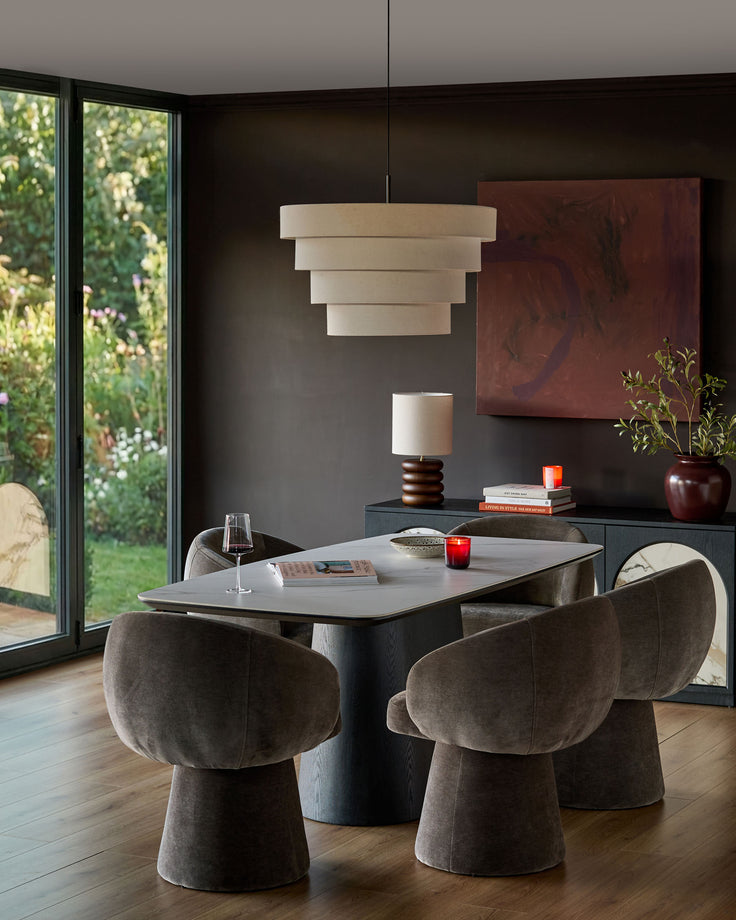 Mocha fabric swivel dining chair with curved barrel back and cylindrical base in modern dining room setting.