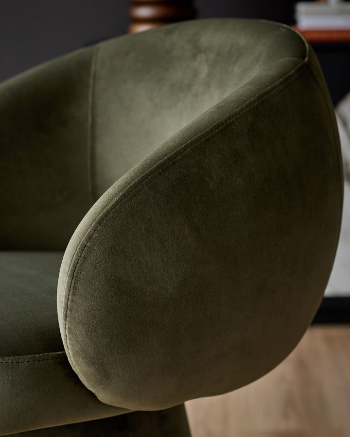 Darcy swivel dining chair in olive green velvet, close-up detail of curved backrest and seaming.