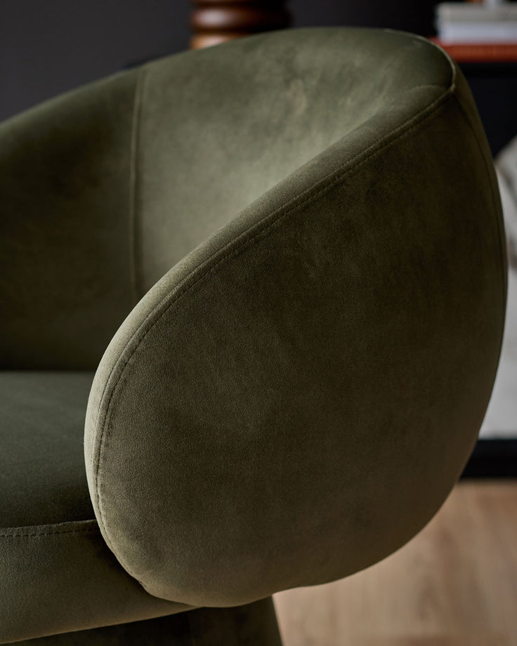Darcy swivel dining chair in olive green velvet, close-up detail of curved backrest and seaming.