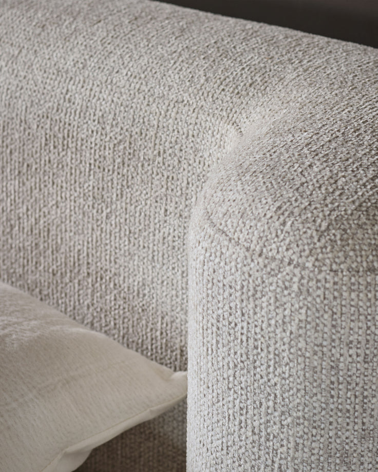 Close-up of natural beige textured fabric on Darla king-size ottoman bed, showing woven upholstery detail and corner seam.