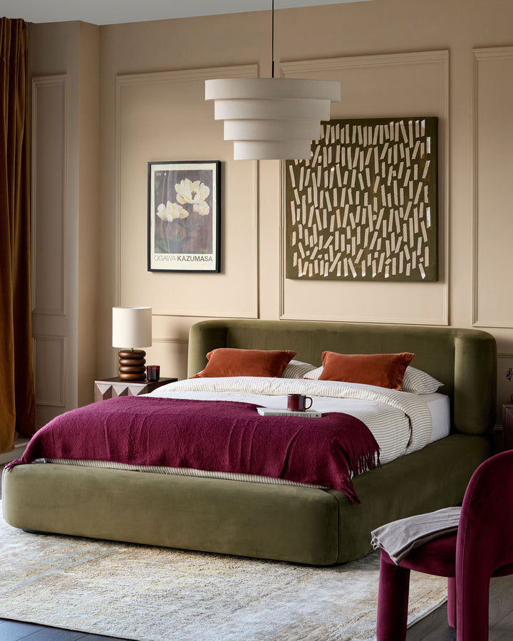 Darla king-size ottoman bed in olive-green velvet, displayed in a styled bedroom with coordinating decor and pendant lighting.