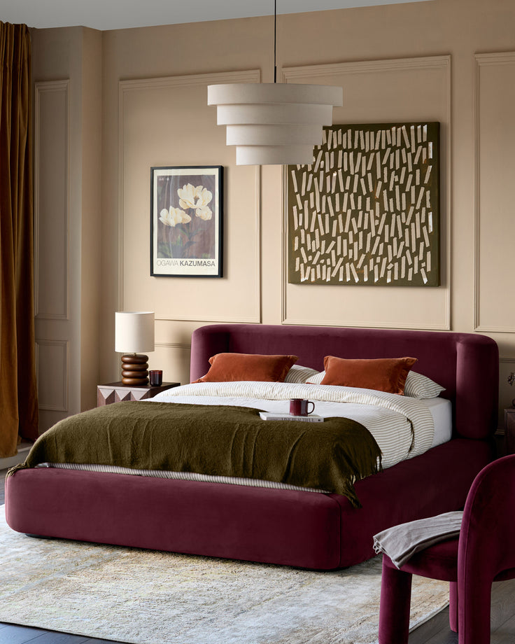 Darla king-size ottoman bed in plum velvet, displayed in a bedroom setting with rounded edges and upholstered design.