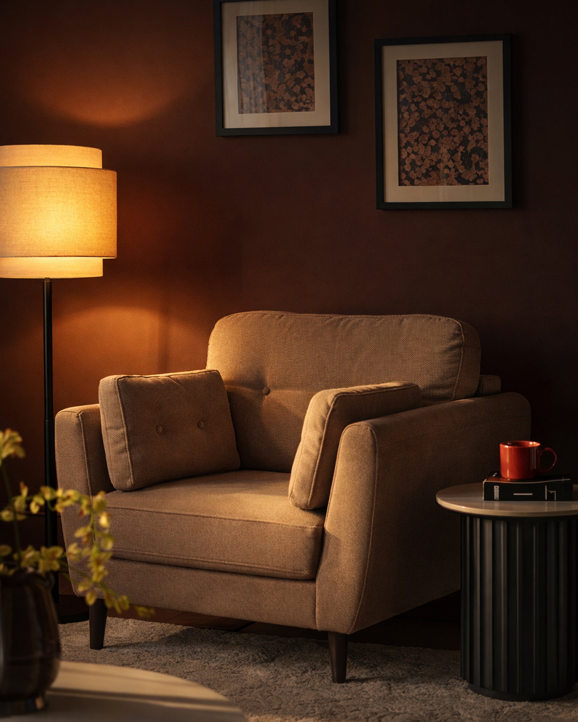 Mocha fabric armchair with rolled arms and tufted back cushion, shown in warm-lit room setting.